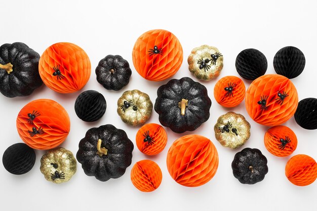 Shiny Decorative Pumpkins and Honeycomb balls. Halloween decorations. Flat lay, top view trendy holiday concept.