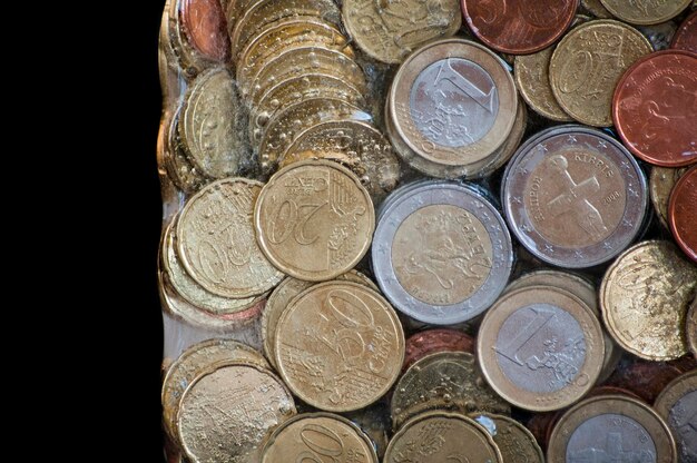 Shiny euro coins frozen in ice