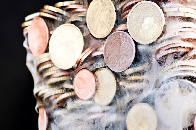 Shiny euro coins frozen in ice