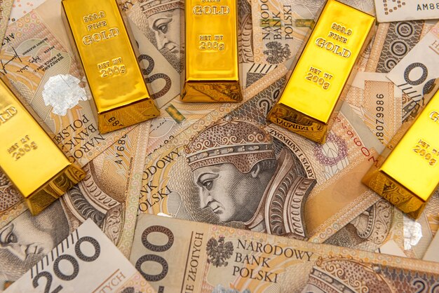 Shiny gold bar on polish zloty. investment and financial concept. currency