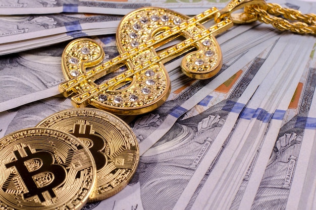 Collana con segno di dollaro in oro lucido e bitcoin fisico su una banconota da un dollaro degli stati uniti