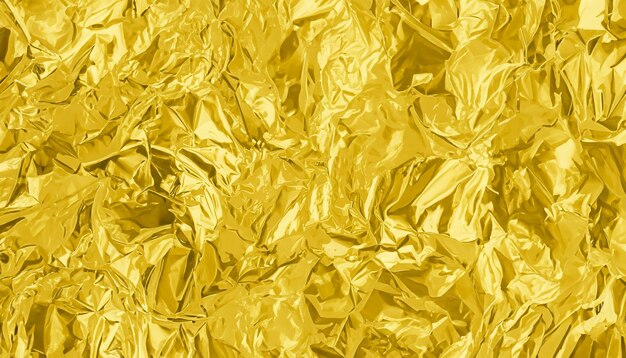 Shiny gold foil texture background pattern of yellow wrapping paper with crumpled and wavy