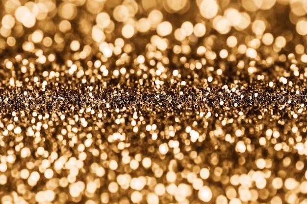 Photo shiny gold glittering background with soft selective focus