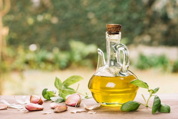 Foto bottiglia di olio d'oliva lucida con gralic all'aperto