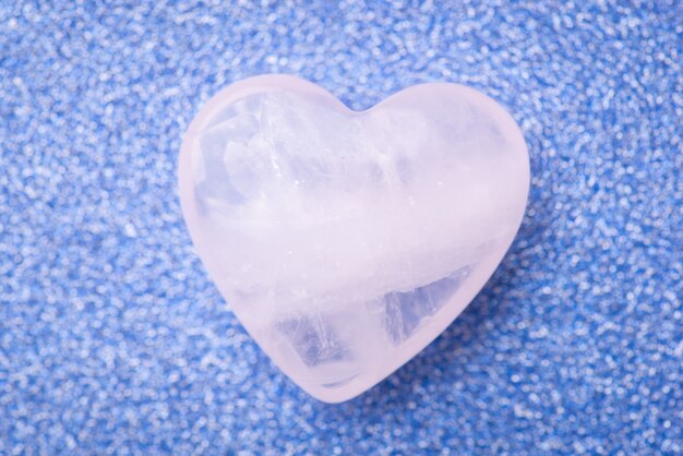 Shiny stone heart on blue background