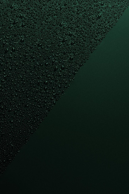 Gocce d'acqua lucide su una superficie nera sfondo di colore verde gocce d'acqua sul nero gocce d'acqua su una superficie di vetro nero trama vista dall'alto