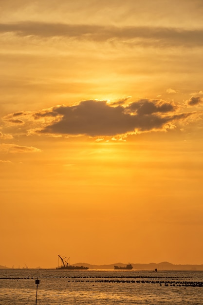 写真 海の上の雲の後ろに船と夕焼け