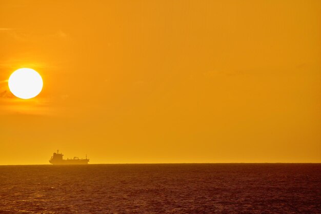 Ship on horizon under the sun