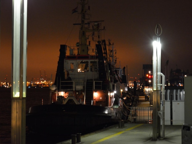 Фото Корабль, пришвартованный в освещенной гавани ночью