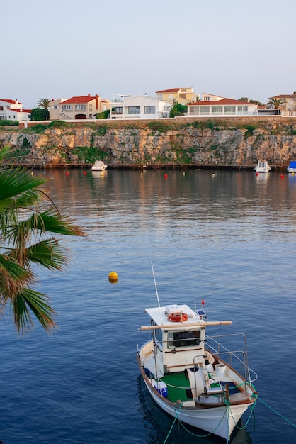 Foto nave ormeggiata nella baia romantico tramonto nel mar mediterraneo dell'isola di minorca