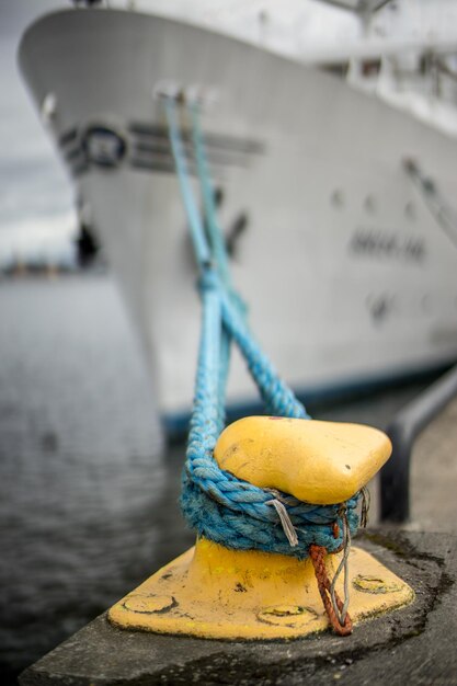 Ship moored by bollard at harbor