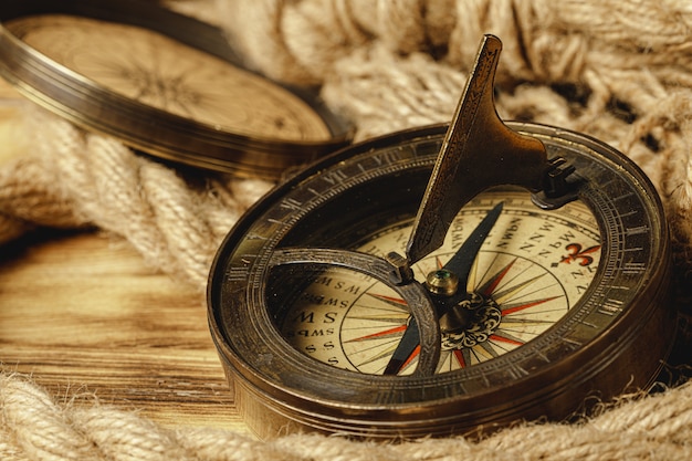 Ship rope and compass on wood