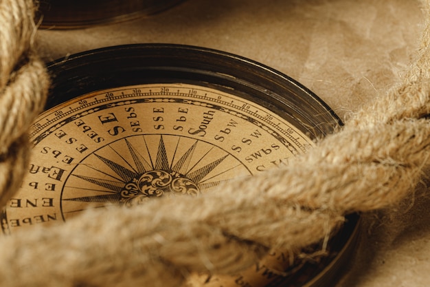 Ship rope and compass on wooden background