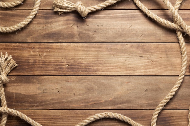 Ship rope at wooden board background texture, top veiw