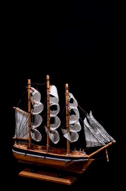 Ship Sailboat Wooden Model Figurine on a Black Background