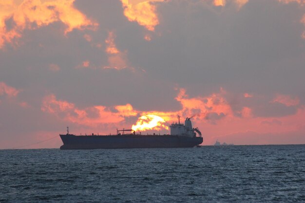 写真 夕暮れの空に逆らって海を航海する船