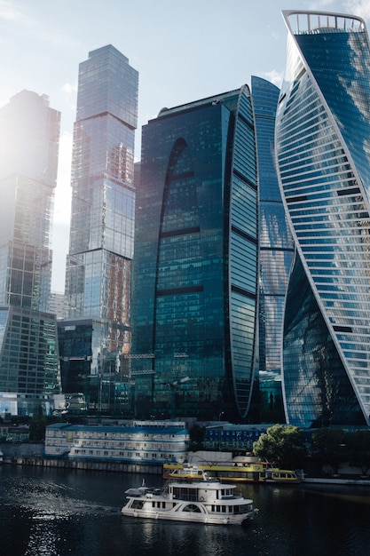 ship sailing on the Moscow river near of Moscow-City skyscrapers with reflection of clouds