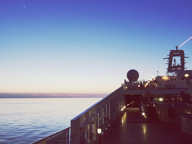 Фото Корабль плывет по морю на чистом небе во время захода солнца