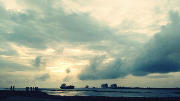 Ship sailing on sea against sky at dusk