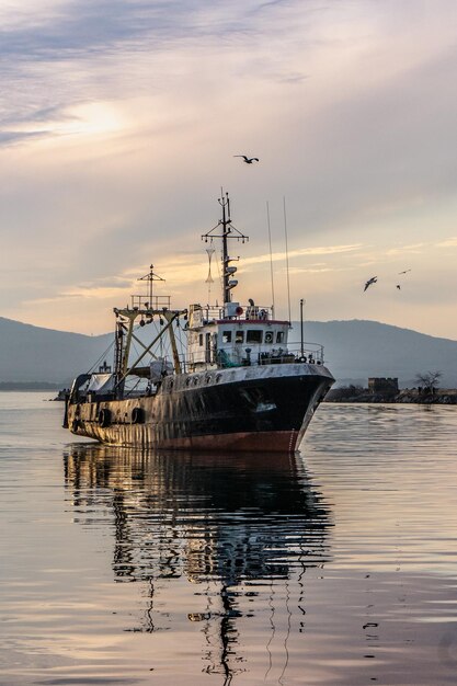 Photo ship in sea against sky during sunset