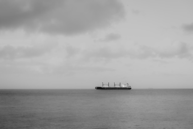 Ship in the sea on the horizon black and white