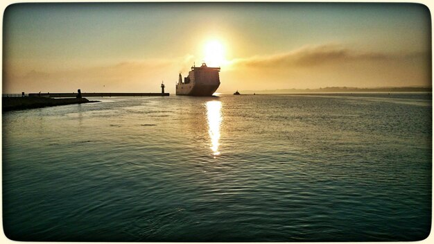 Photo ship in sea at sunset