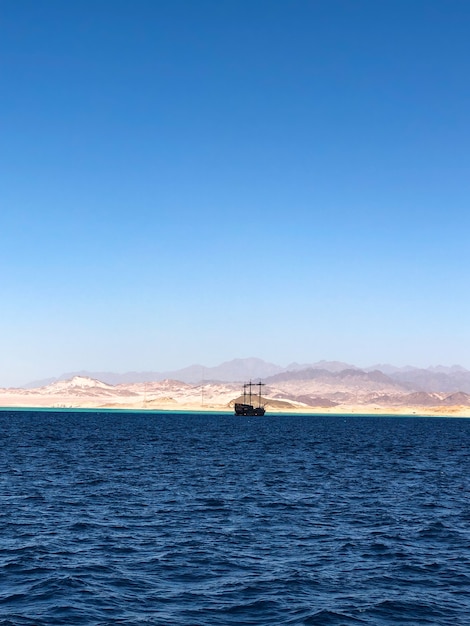 Photo ship yacht boat on horizon line egypt. panoramic view blue sea surface far from coast