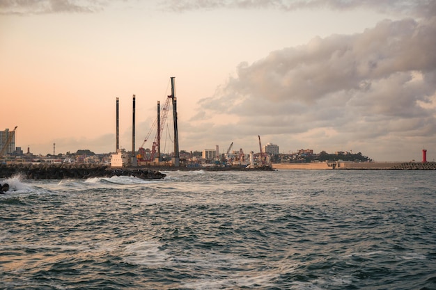 Shipping cargo port and shipyard on coastline in the evening