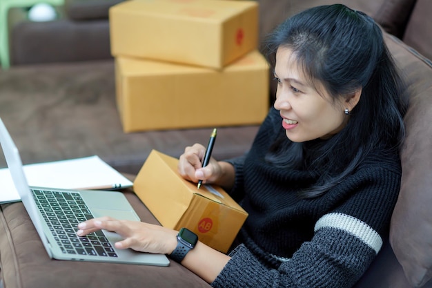 Foto spedizione online donna asiatica avviare un piccolo imprenditore la lista di controllo accetta l'ordine online