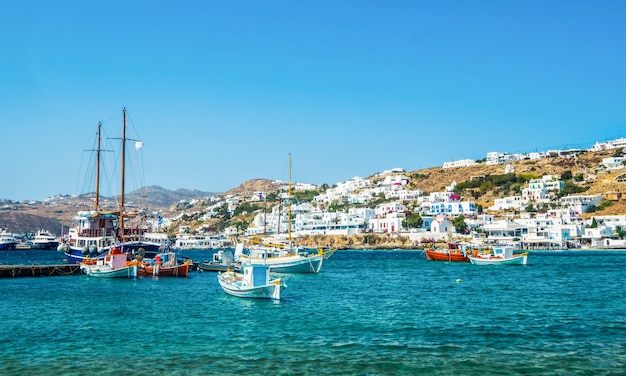 Ships on blue water with Mykonos island