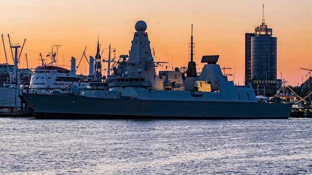 ships moored at harbor during sunset