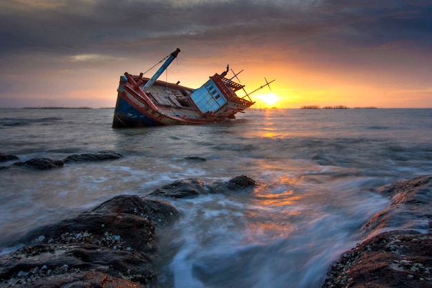 Un naufragio attraccato dal mare durante il tramonto