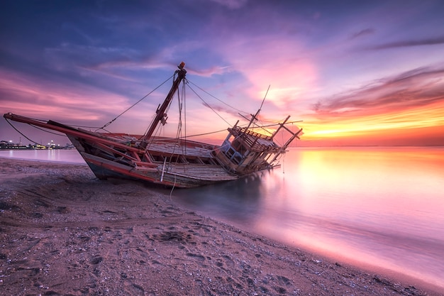 写真 夕暮れ時のビーチでの難破船