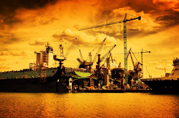 Photo shipyard ship under construction repair industrial machinery crane transport