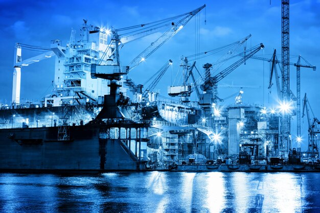 Photo shipyard at work ship repair industrial machinery cranes transport freight concept