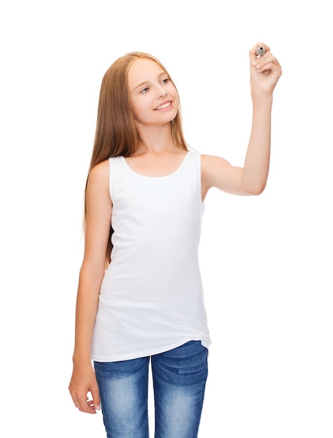 концепция дизайна рубашки - улыбающаяся девочка-подросток в пустой белой рубашке рисует или пишет что-то в воздухе