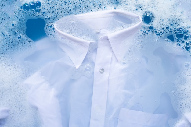 シャツは粉末洗剤の水に浸します。ランドリーのコンセプト