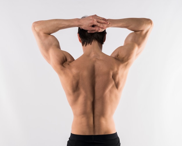 Shirtless athletic man showing off back muscles. 