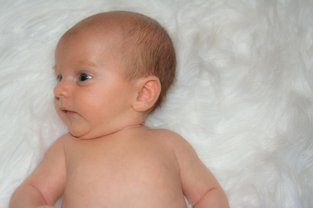 Shirtless baby boy lying on rug