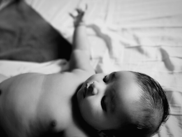 Photo shirtless baby girl lying on bed