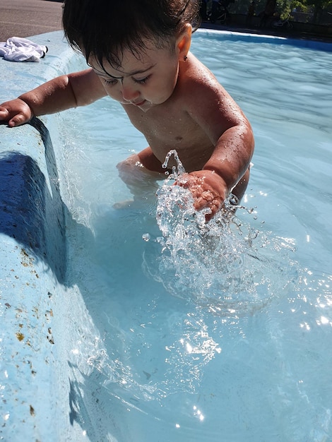 Shirtless baby girl in swimming pool