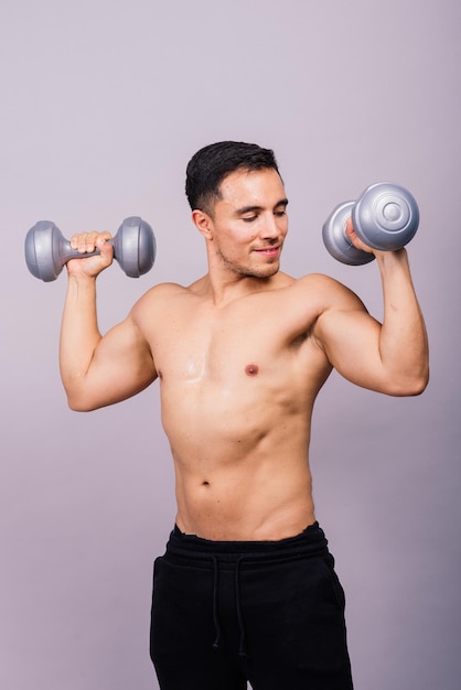 Shirtless bodybuilder showing his great body and holding dumbell