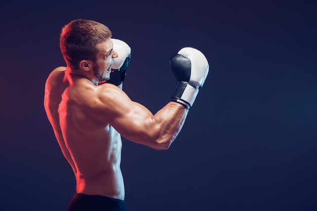 Shirtless bokser met handschoenen op donkere achtergrond. Isoleren