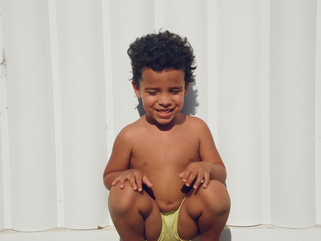 Photo shirtless boy against wall