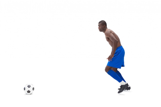 Shirtless football player moving to the ball