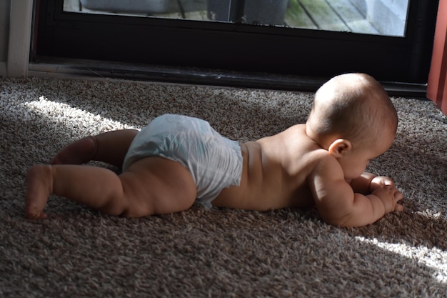 Photo shirtless girl lying on rug at home