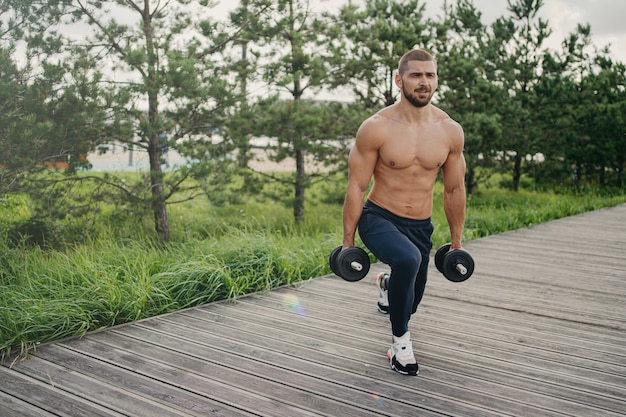 Shirtless man buitenshuis trainen met gewichten