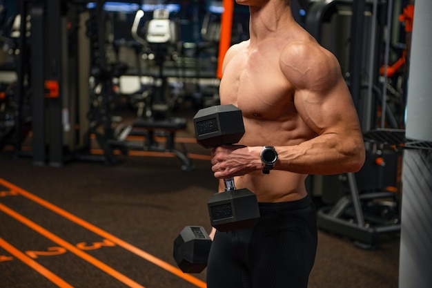 Premium Photo  Shirtless man crop view doing biceps triceps workout with  dumbbells in gym strength training