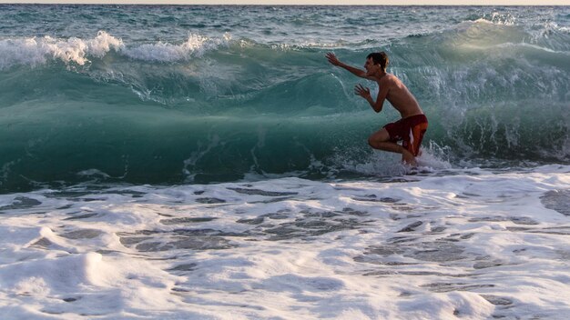 写真 シャツなしの男が海を楽しんでいる