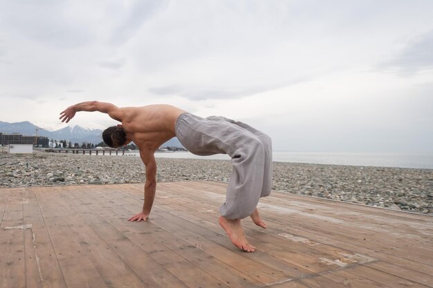 Photo shirtless man exercising at beach